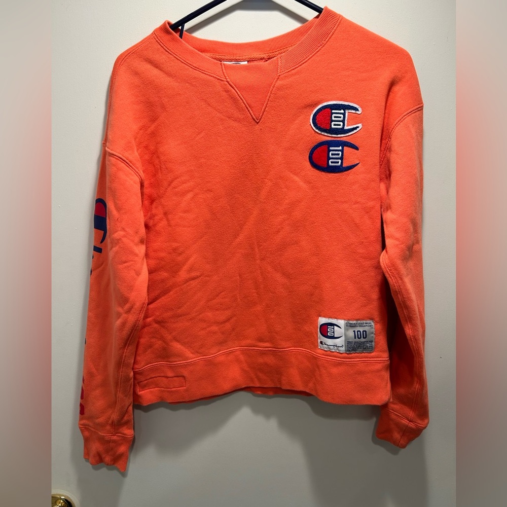 Champion, small coral sweatshirt.  Crew neck.  Detail on arm.